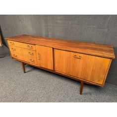 a large wooden dresser sitting on top of a carpeted floor next to a wall