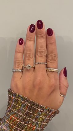 a woman's hand with three different rings on her fingers and one ring in the middle