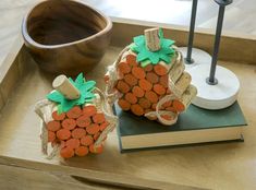 two pumpkins made out of cork sit on a tray