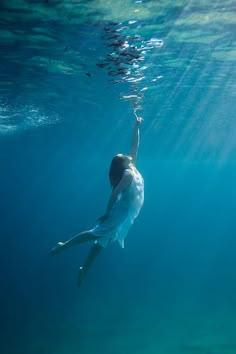 a man is swimming in the ocean with his arms up to the water's surface