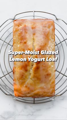 a close up of food on a wire rack with text overlay that reads, super moist glazed lemon yogurt loaf