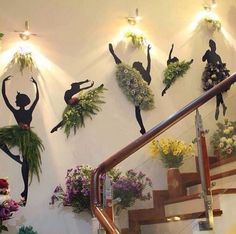 the dancers are hanging on the wall above the stairs and flowers in vases behind them