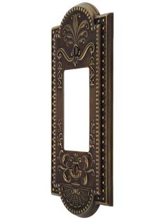 an ornate metal switch plate cover on a white background