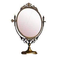 an antique looking mirror on a stand against a white background