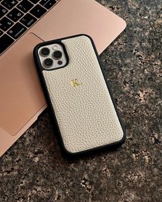 an iphone case sitting on top of a laptop computer next to a macbook pro