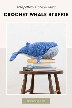 a blue whale stuffed animal sitting on top of books