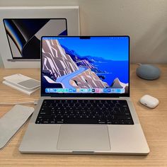 an open laptop computer sitting on top of a wooden desk next to a mouse and keyboard