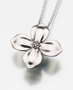 a silver necklace with a flower on it