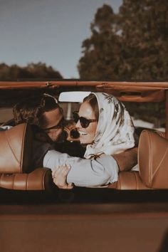 a man and woman sitting in the back of a car