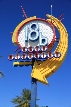 a big sign that is on the side of a building in front of some palm trees