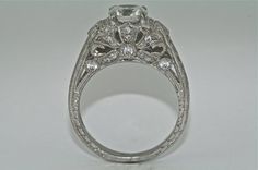 an antique style diamond ring with filigrees on the sides