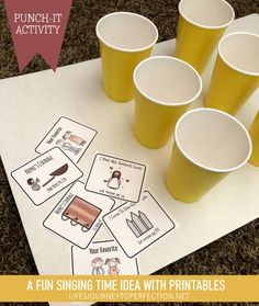 a bunch of cups sitting on top of a table with some cards in front of them