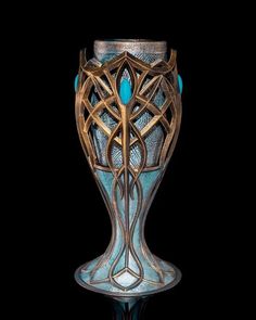 a glass vase with an intricate design on the bottom and sides, sitting on a black surface