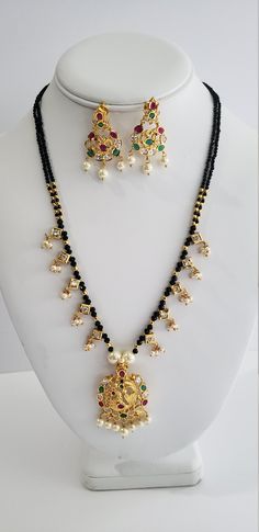 Mangalsutra is importance in Hindu culture and traditions. It is an ornament more specifically a necklace worn by women to signify marital status. Therefore, the groom tying the Mangalsutra around the bride's neck during the wedding rituals is considered a sacred Hindu custom. The American Daimonds and black beads combination necklace is unique and beautiful. The superior quality stones in these make this gorgeous Indian jewelry a must have jewelry. Each piece is handcrafted and made to orders. Traditional Black Mala As A Gift, Spiritual Black Jewelry For Puja, Black Round Beads Necklaces For Puja, Black Round Beaded Necklaces For Puja, Black Beaded Necklaces For Diwali, Black Beaded Necklaces For Puja And Festivals, Black Beaded Necklace For Diwali, Festive Black Beads Necklace For Puja, Spiritual Black Necklace For Festivals