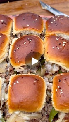 a close up of a plate of food with sliders on it and a knife in the background