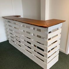 a wooden counter made out of pallets in an office space with carpeted flooring