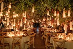 the tables are set with candles and paper lanterns hanging from the trees in the background