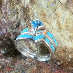 This beautiful Sterling Silver Ring Set, as part of the Arizona Blue Collection features Kingman Turquoise with a Blue Topaz. Engagement Ring Width: Top 5/8"; Shank 1/8" Band Width: 1/4"; Shank 1/8" The ring is designed by David Rosales, one of the finest contemporary Southwest Artists in the world. He is the founder and co-owner of Supersmiths, Inc. of Gallup, NM. Each ring is custom made and carries a lifetime guarantee. Blue Multi-stone Opal Ring Fine Jewelry, Fine Jewelry With Inlay For Anniversary, Blue Multi-stone Turquoise Ring In Sterling Silver, Unique Blue Turquoise Multi-stone Ring, Unique Blue Multi-stone Sapphire Ring, Blue Aquamarine Fine Jewelry, Turquoise Sapphire Ring With Accent Stones, Fine Jewelry Turquoise Sapphire Ring With Accent Stones, Blue Multi-stone Opal Ring In Fine Jewelry Style