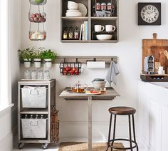 the kitchen is decorated in white and has lots of items on shelves, including an old table