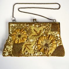 A beautiful vintage hand made evening bag, from the first half of the 20th century. Gold satin, heavily decorated with glass seed beads, sequins, embroidery and applique flowers. The bag has a gold metal kiss clasp and chain strap attached to a gold metal frame.  The front is in very good pre-loved condition. There are some light marks on the 'flowers' and the back has a few marks which can be seen in pics. It is lined with gold satin and has an inner pocket, in excellent condition.  Dimensions: approx 22cm at the widest point x 12cm high (not inc. strap) Shipped by Royal Mail tracked service. Antique Gold Embroidered Bags, Victorian Style Gold Embroidered Bag, Vintage Gold Embroidered Evening Bag, Gold Vintage Embroidered Evening Bag, Vintage Evening Bag With Handwork For Formal Occasions, Vintage Handwork Evening Bag For Party, Vintage Handwork Evening Bag For Wedding, Vintage Wedding Evening Bag With Handwork, Vintage Wedding Bags With Gold Embroidery