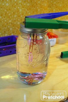 a glass jar filled with colored paper clips