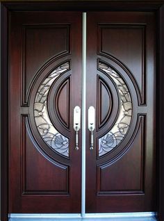 a pair of double doors with decorative glass and metal handles on the front entrance to a home