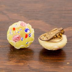 two pieces of glass sitting on top of a wooden table next to a metal object