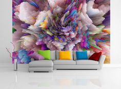 a living room with a white couch and colorful wall mural on the wall behind it