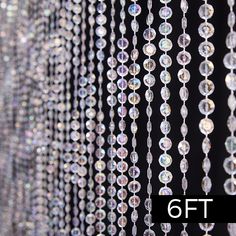 many crystal beads hanging from the side of a black wall next to a sign that says 9ft