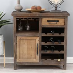 a wooden cabinet with wine bottles and glasses