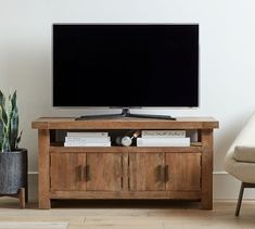 a flat screen tv sitting on top of a wooden stand