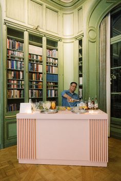 a man sitting at a table in front of bookshelves