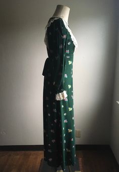 "1970s handmade prairie dress cotton w/lace trim zip up back ties below bust front to back long sleeve w/elastic wrist cuff dark green w/multi-color floral pattern very good vintage condition, light wear no size label tag (measures like xs/s but please go by measurements) measures, lying flat, shoulder-14 1/2\" bust-16 1/2\" waist-14\" hip-22 1/2\" sleeve-23\" length-51\"" Green Long Sleeve Cottagecore Dress, Green Lace Trim Dress For Fall, 1970s Green Long Sleeve Dress, 1970s Style Green Long Sleeve Dress, Vintage Floral Print Winter Dress, Vintage Long Sleeve Green Dress, Cocktail Dress Vintage, Prairie Dress, Vintage Cocktail