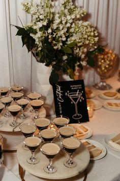 there are many glasses on the table ready to be filled with drinks and desserts