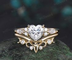 a heart shaped diamond ring on top of a rock