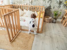 a small dog standing next to a wooden crib