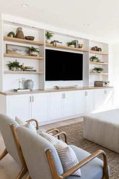 a living room filled with furniture and a flat screen tv mounted on a wall above it