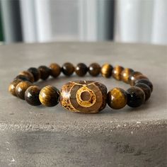 Authentic | High Grade | USA | 3 Days Free Shipping | ASANA Check out our stunning Tiger's eye Tibetan bracelet! Stone: Tiger's Eye - Origin: Tibet - Uses: Luck & Protection Looking for something special to add to your jewelry collection? Check out our gorgeous tiger's eye bracelet! This bracelet is crafted with beautiful tiger's eye beads, each one unique in its colors and patterns. Wear this bracelet as a reminder to stay grounded and connected to your true power. Tiger's eye is known for its Symbolic Beaded Bracelets With 8mm Beads, Brown Bracelet With Spacer Beads As Gift, Brown Bracelet With Spacer Beads For Gift, Brown Bracelets With Spacer Beads As Gift, Brown Bracelets With Spacer Beads For Gifts, Spiritual 8mm Beads Bangle Bracelet, Spiritual Beaded Bangle Bracelets With 8mm Beads, Spiritual Brown Beaded Bracelets With Gemstone Beads, Spiritual Brown Gemstone Beaded Bracelets