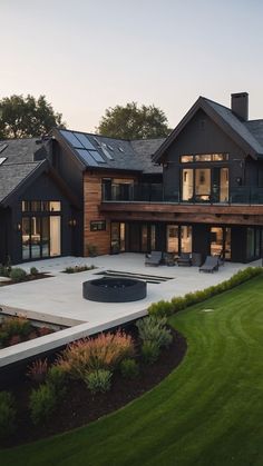 a large house with a pool in front of it and lots of grass on the ground