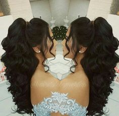 the back of a woman's head with long black hair and blue bra top