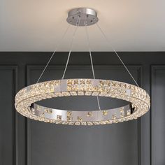 a chandelier hanging from the ceiling in a room with black walls and flooring