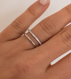 a woman's hand with two rings on it and one is wearing a diamond ring