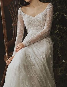 a woman in a wedding dress sitting on a chair