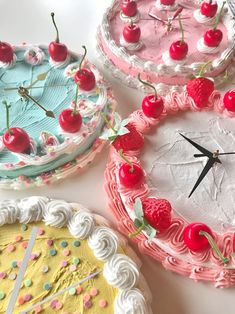 four cakes decorated with cherries and sprinkles