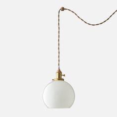 a white light hanging from a gold colored cord