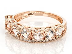 a rose gold ring with five stones on the side and two rows of diamonds in each band