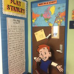 a classroom door decorated with a paper cutout of a boy pointing at a map