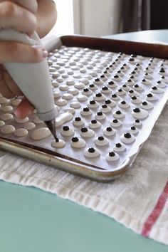 a person is using a pen to draw circles on a sheet of white paper with black dots