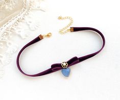 This eye-catching choker necklace is handmade with a soft velvet ribbon in a deep eggplant purple hue. It features a velvet bow, a pearl beaded jewel and a pretty faceted blue heart charm. A one-of-a-kind birthday, anniversary or just because I love you gift for women and girls. * Size ~ Adjustable length 12 - 15 inches with extender chain  Please check your neck size carefully as I do not accept returns or exchanges on these necklaces. Contact me prior to purchase. I am happy to adjust the size Purple Necklaces For Valentine's Day Party, Purple Necklace For Valentine's Day Party, Adjustable Purple Choker For Party, Purple Choker Necklace For Gift, Heart-shaped Ribbon Jewelry For Parties, Rosy Posy, Stone Choker, Beaded Jewels, Velvet Choker