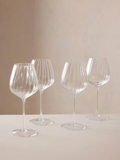 four wine glasses lined up on a table